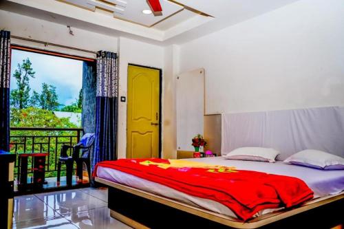 a bedroom with a bed with a yellow door and a balcony at HOTEL SAMRUDDHI in Panchgani