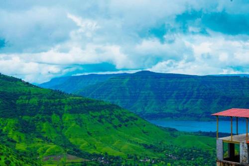 a view of a green valley with a lake at HOTEL SAMRUDDHI in Panchgani