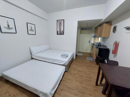 um pequeno quarto com duas camas e uma mesa em ANIA ROOMS@AMANI GRAND RESIDENCES NEAR AIRPORT em Mactan