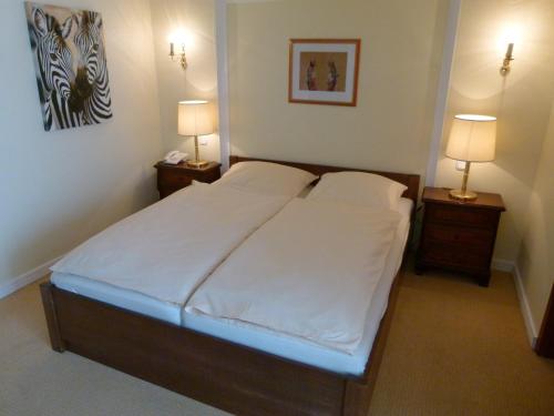 a bedroom with a large bed with two night stands at Schökel´s Hotel und Restaurant in Elze