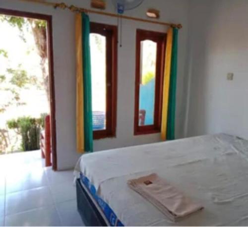 a bedroom with a bed and a window at Romantic Homestay in Kuta Lombok
