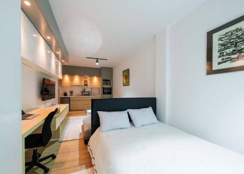 een slaapkamer met een bed, een bureau en een keuken bij Luxurious/ Modern Studio in Nairobi