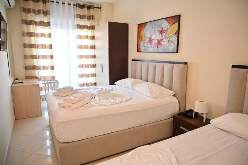 a bedroom with two beds with towels on them at Hotel Zanzi in Durrës