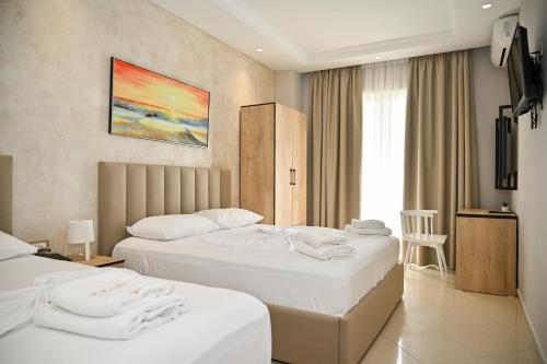 a hotel room with two beds with towels on them at Hotel Zanzi in Durrës