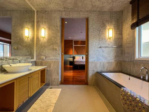 ein großes Badezimmer mit Badewanne und Waschbecken in der Unterkunft Hua Hin Blue Lagoon-Pool Access in Cha-am