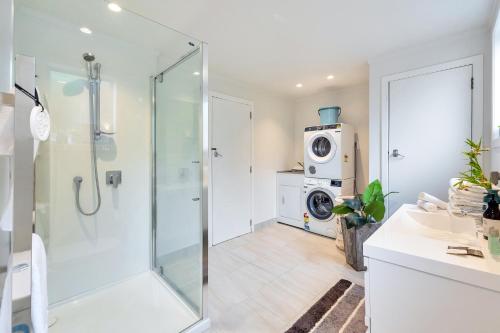 a bathroom with a shower and a washing machine at Bright Kingsland Contemporary in Auckland