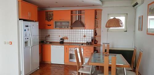 a kitchen with orange cabinets and a table with chairs at Dimoski Apartment in Prilep