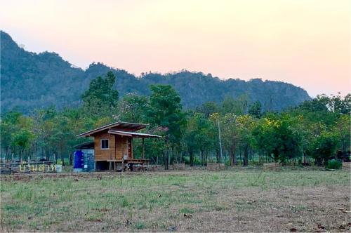 a small house in the middle of a field at บ้านส่าหรีโฮมสเตย์ in Lan Sak