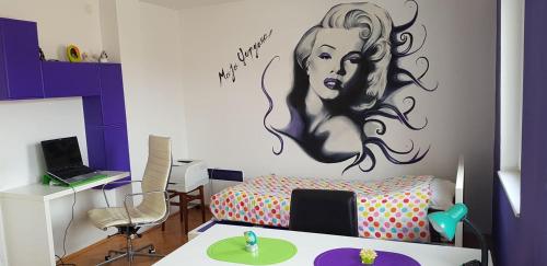 a room with a wall with a painting of a woman at Dimoski Apartment in Prilep