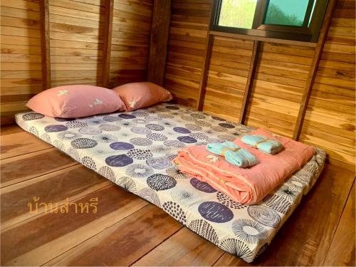a small bed in a room with two pillows at บ้านส่าหรีโฮมสเตย์ in Lan Sak