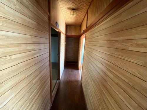 a room with wooden walls and a hallway at 三浜館 伊豆大島 in Oshima