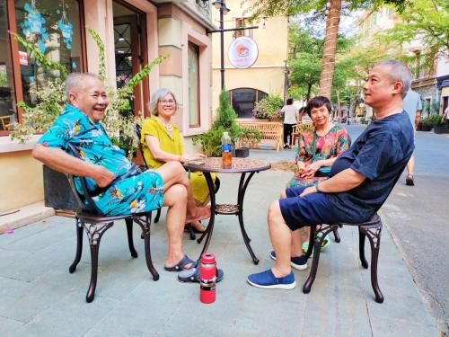 eine Gruppe älterer Menschen, die an einem Tisch sitzen in der Unterkunft Sunset Hotel Phu Quoc - welcome to a mixing world of friends in Phu Quoc