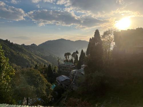 a view of a mountain with the sun in the background at Graham Hill’s Stay in Darjeeling