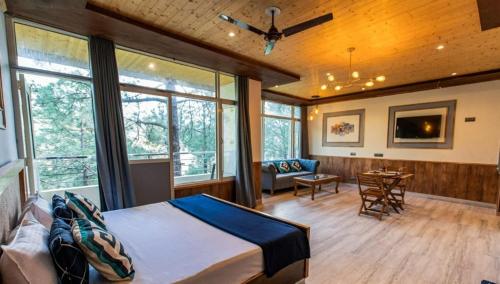a bedroom with a bed and a living room at Pinewood Nirvana Jungle Resort Shoghi in Shimla