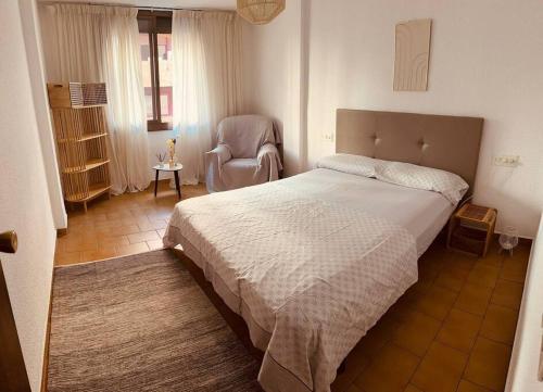 a bedroom with a large bed and a chair at Apartament Central Castellon! in Castellón de la Plana