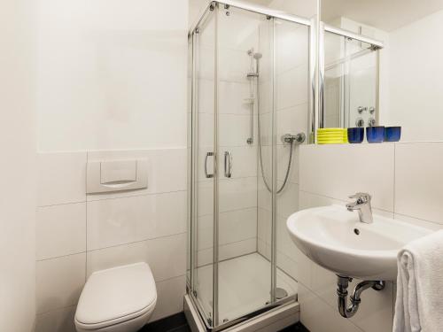uma casa de banho com um chuveiro, um WC e um lavatório. em MaxAparthotel by homekeepers em Fürth