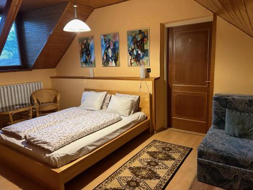 a bedroom with a bed and a door and a rug at Galéria Vendégház in Mezőkövesd
