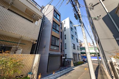 eine Gasse zwischen zwei Gebäuden in einer Stadtstraße in der Unterkunft APB高円寺 in Tokio