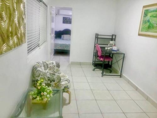 a hallway with a chair and a table with a bed at Bienvenido a Casa centro 152, a 2 min de consulado in Matamoros