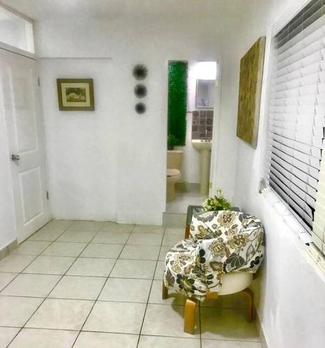 a living room with a chair and a bathroom at Bienvenido a Casa centro 152, a 2 min de consulado in Matamoros