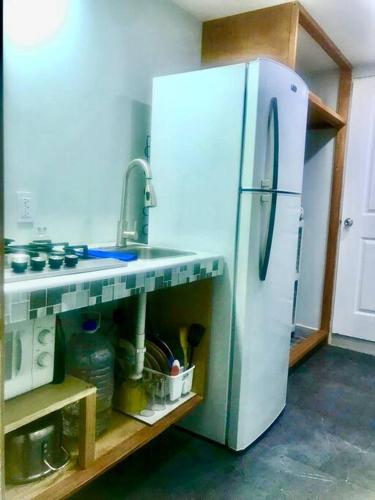 a kitchen with a white refrigerator and a sink at Bienvenido a Casa centro 152, a 2 min de consulado in Matamoros