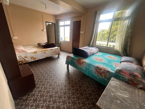 a room with two beds and a window at Graham Hill’s Stay in Darjeeling