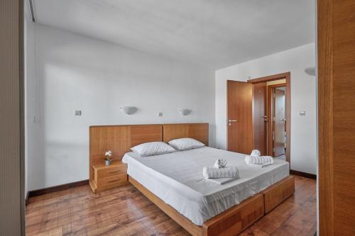 a bedroom with a large bed with a wooden headboard at Charming 2BD Guest House in Sozopol in Burgas City