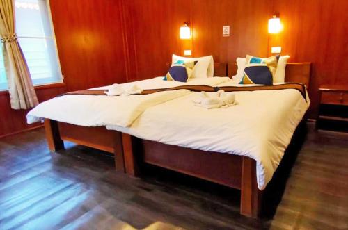 sypialnia z 2 łóżkami z białą pościelą w obiekcie Vang Vieng Garden Villa w mieście Vang Vieng