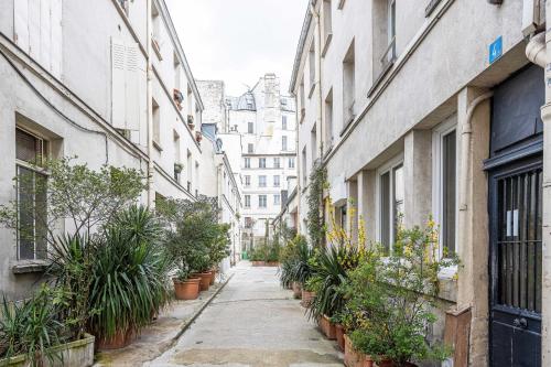 巴黎的住宿－ParisMyHome - Air-conditioned, 2 shower rooms, 2 toilets，种植了盆栽植物和建筑的小巷