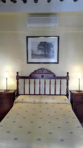 a bed in a bedroom with two night stands and two lamps at Sierra Alcaide in Zagrilla