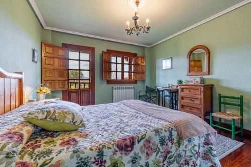 Un dormitorio con una cama grande y una mesa. en Casa Montañesa, en El Astillero