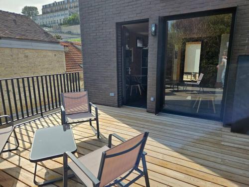 deux chaises et une table sur une terrasse en bois dans l'établissement Studio indépendant avec terrasse, à Le Pecq