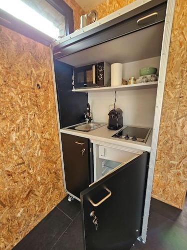 une petite cuisine avec un évier et une cuisinière dans l'établissement Studio indépendant avec terrasse, à Le Pecq