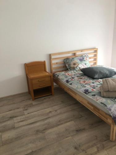 een slaapkamer met een bed en een nachtkastje bij Przy wiadukcie in Tarnów