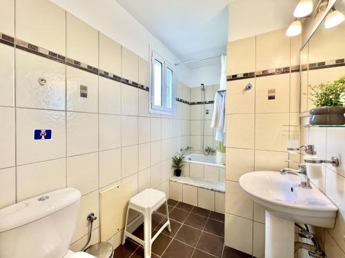 a bathroom with a toilet and a sink and a tub at Beachfront Suites GardenMare by DadoVillas in Litherés