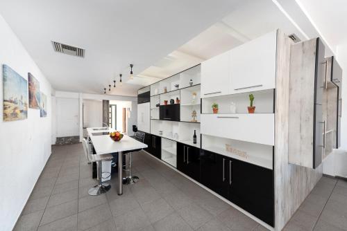 a kitchen with white and black cabinets and a table at Coastal Dream beachView Jacuzzi& sauna free parking WiFi 2 bedroom in Amoudara Lasithiou