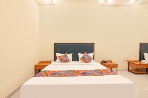 a bedroom with a large white bed with pillows at FabHotel Mint Park in Hyderabad