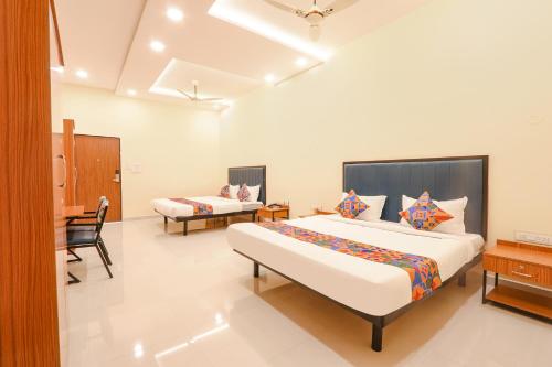 a bedroom with a large bed and a desk at FabHotel Mint Park in Hyderabad