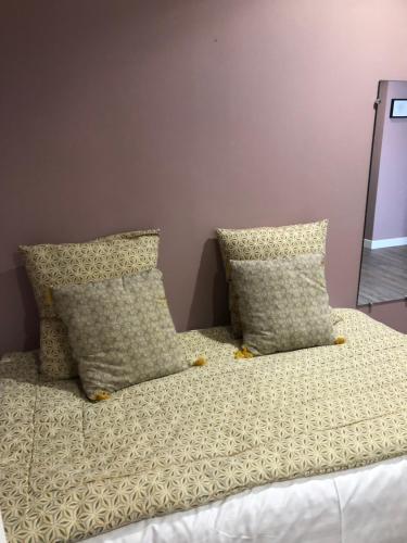 a bed with two pillows on top of it at Hotel Les Embruns in Le Touquet-Paris-Plage