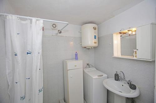 a bathroom with a sink and a toilet and a shower at Paraporti Rooms in Andros