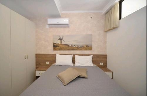 ein Schlafzimmer mit einem Bett und einer Windmühle an der Wand in der Unterkunft Langust - free parking in Sveti Stefan