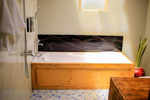 a bathroom with a wooden tub and a shower at Amanya Hut 3-Bedroom House Amboseli in Amboseli