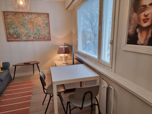 um quarto com uma mesa e cadeiras e uma janela em Studio Porin Otso, home away home in Pori city center em Pori