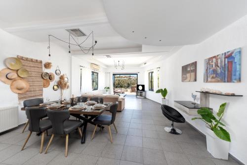 a dining room and living room with a table and chairs at Coastal Dream beachView Jacuzzi& sauna free parking WiFi 2 bedroom in Amoudara Lasithiou