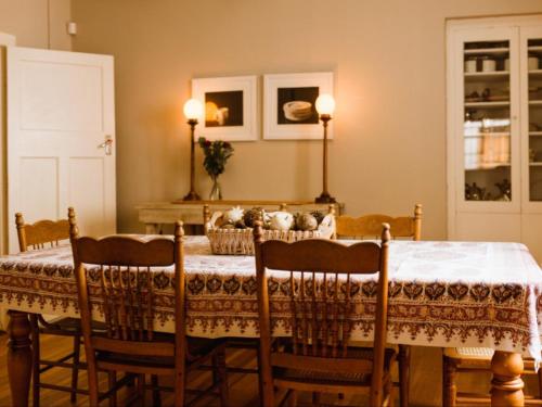a dining room with a table with chairs and a white table cloth at Sewefontein Guest Farm in Citrusdal