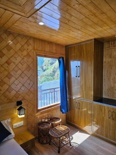 1 dormitorio con ventana en una cabaña de madera en Zen Homestay en Cheog