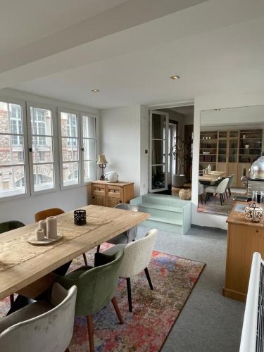 un salon avec une table et des chaises en bois dans l'établissement Logement en Hôtel Particulier à 3mns de Paris et de 3 sites olympiques avec grand jardin et Jacuzzi, à Boulogne-Billancourt