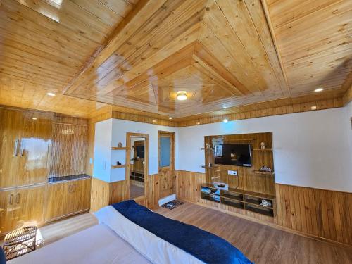 1 dormitorio con techo de madera, 1 cama y TV en Zen Homestay en Cheog