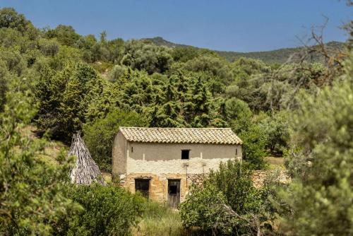 an old stone house in the middle of a forest at Soul Valley all-in boutique hotel with yoga & wellness in Maracalagonis