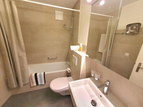 uma casa de banho com um lavatório, um WC e um chuveiro em - fantastic mountain panorama em Davos